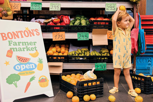 Un petit garçon joue avec les fruits dans un supermarché