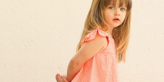 Une petite fille porte une robe en vichy Bonton